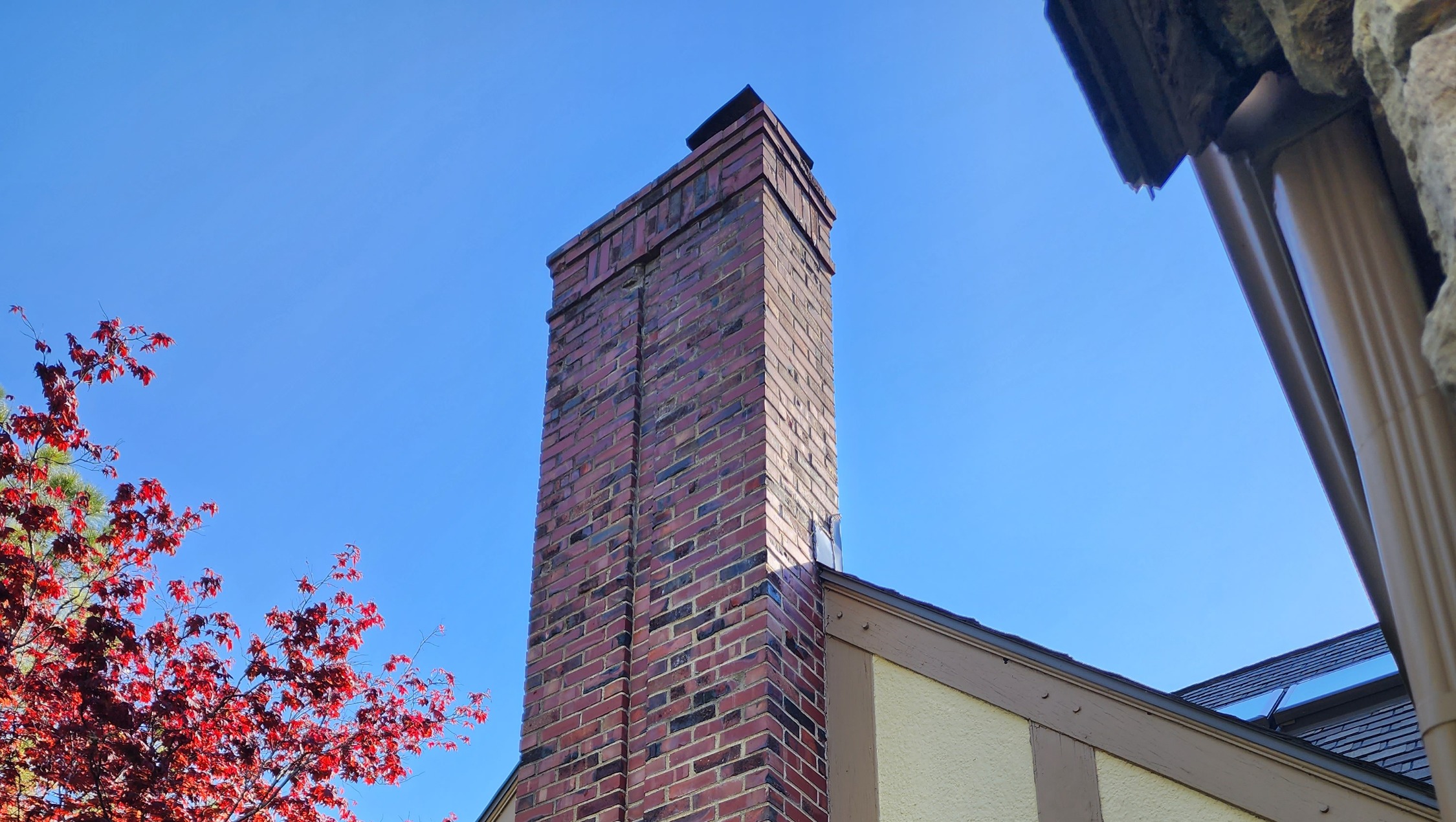 Brick chimney repair above the roofline